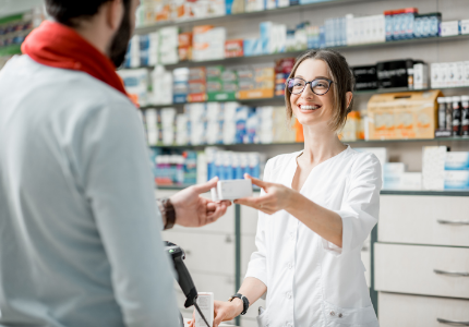 Pharmacist handing medicine to customer