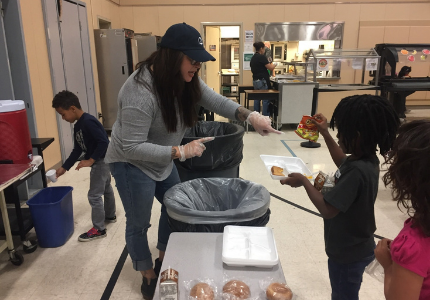 Teacher handing out food to students