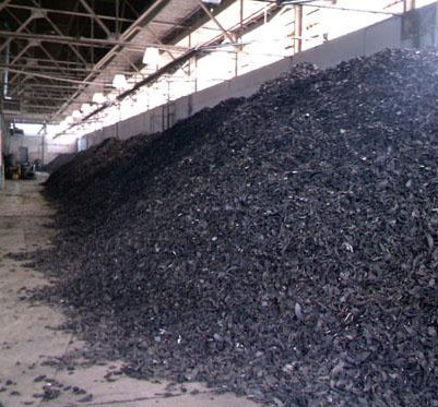 Large mound of whole tires size-reduced into shreds for tire-derived fuel