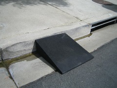 Curb ramp, made from recycled tires, leading from road to sidewalk