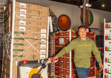 Volunteer pulling food donations with a hand truck