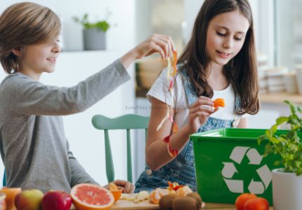 Young boy and girl put food scraps into a kitchen compost bin
