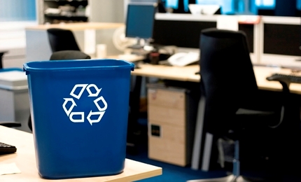 Blue recycling bin with recycling logo in an office