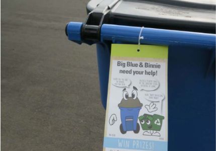 Blue curbside bin with contamination tag attached to it.