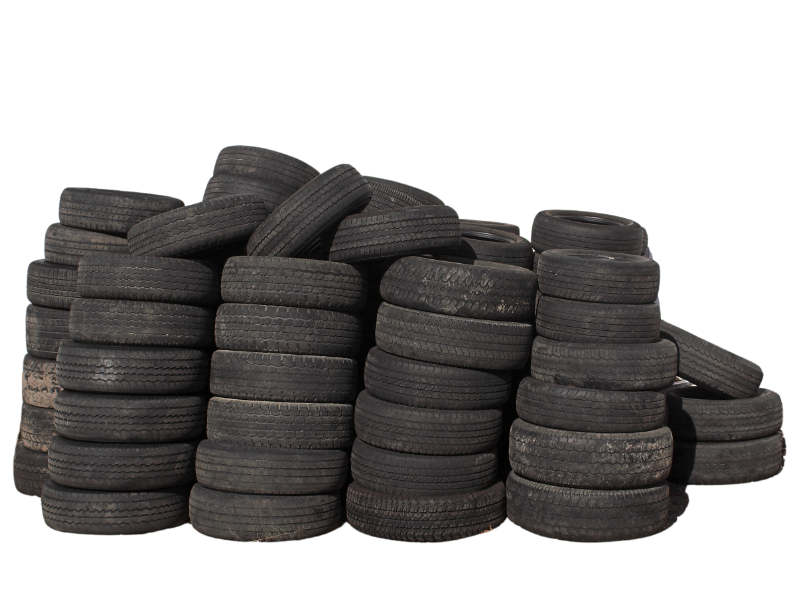 The image shows a large pile of used tires, varying in size and showing signs of wear, stacked against a white background.