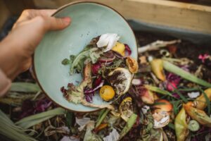 bowl of food scraps being tossed in a food scrap bin